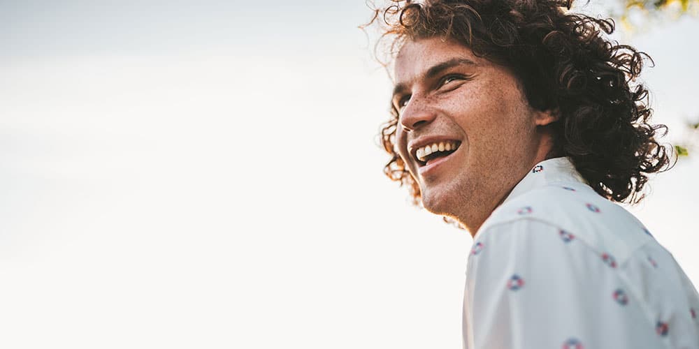 young man smiling and looking in the distance